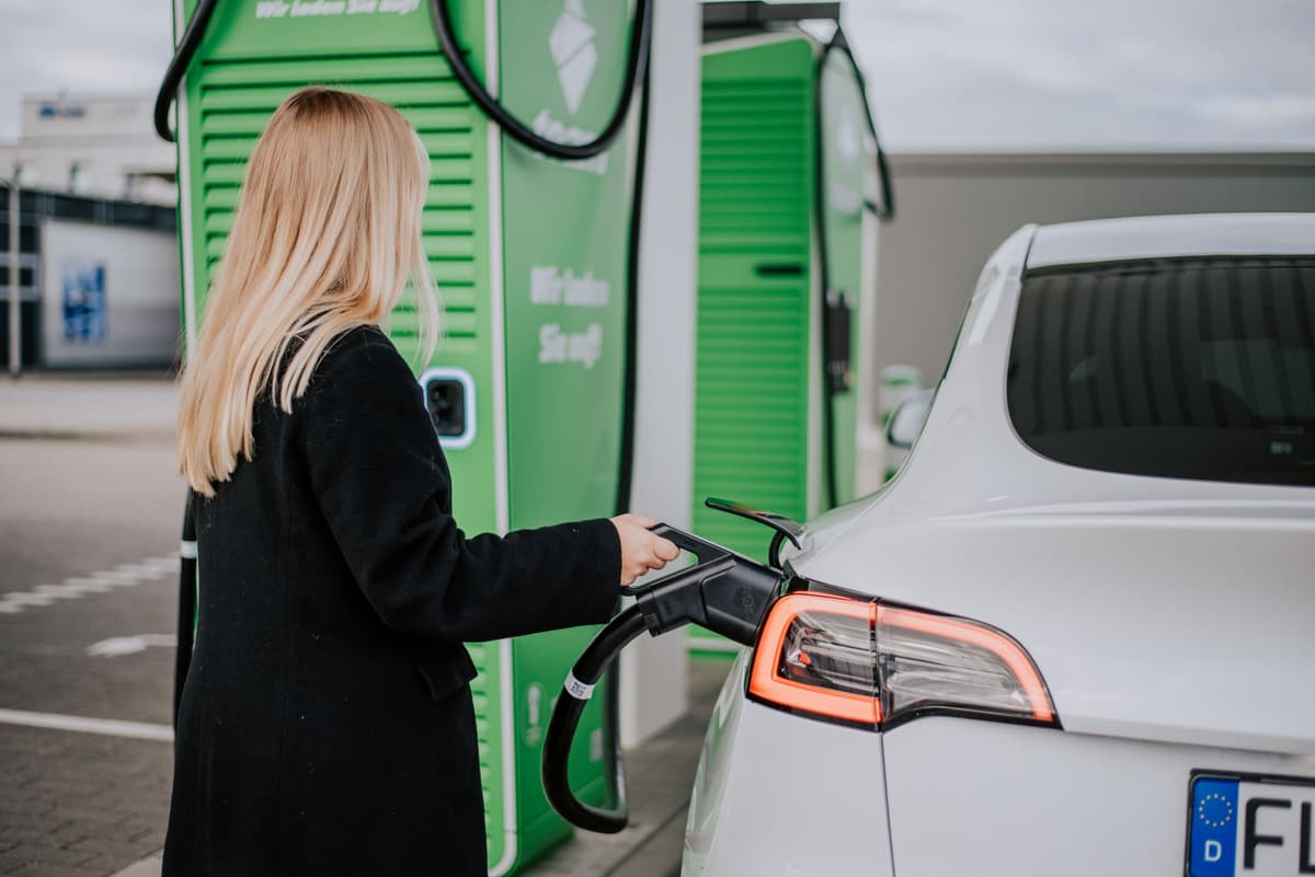 A woman charging her car at a Team charging station.